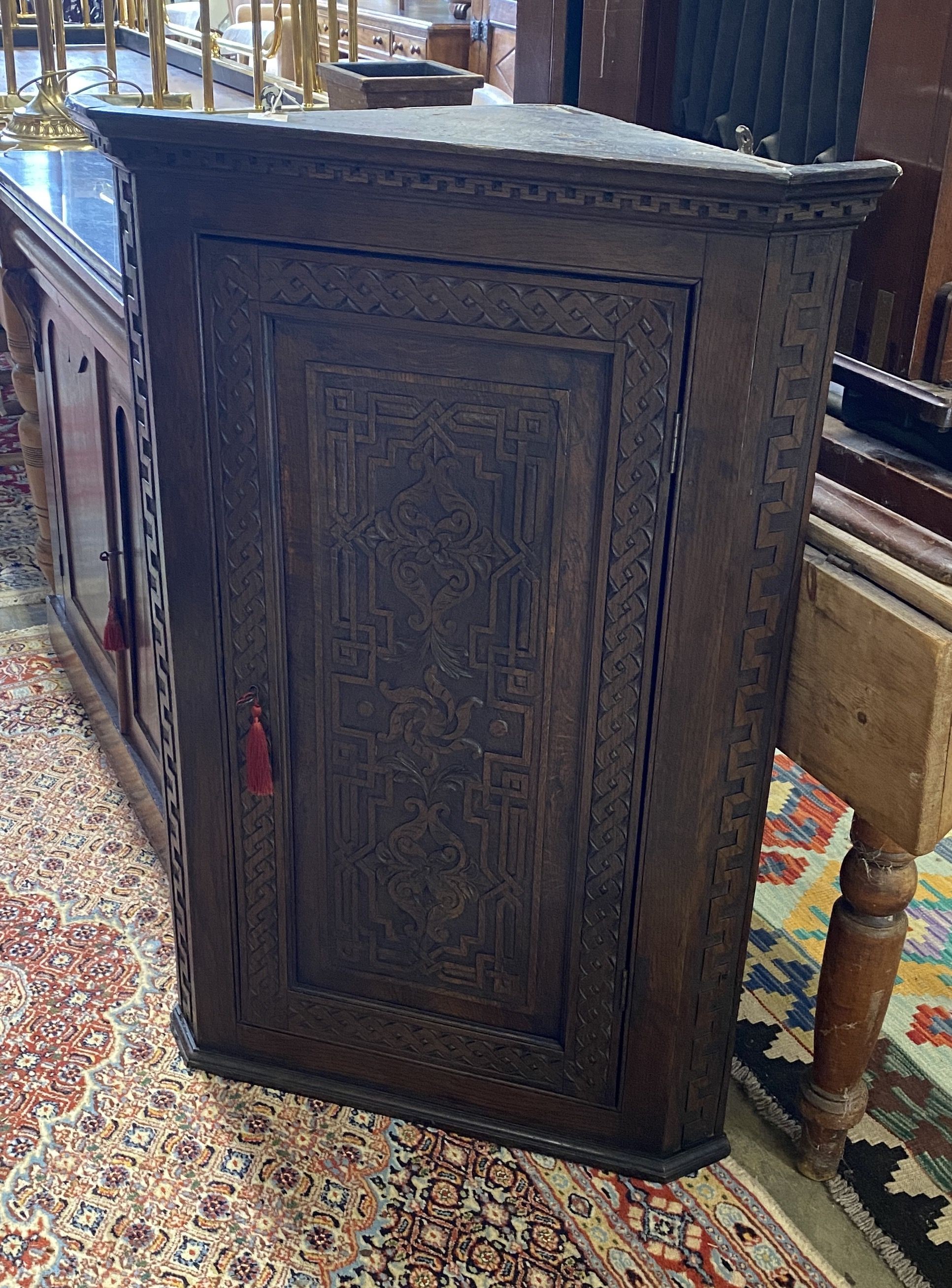 A George III later carved oak hanging corner cabinet, width 72cm, depth 42cm, height 105cm